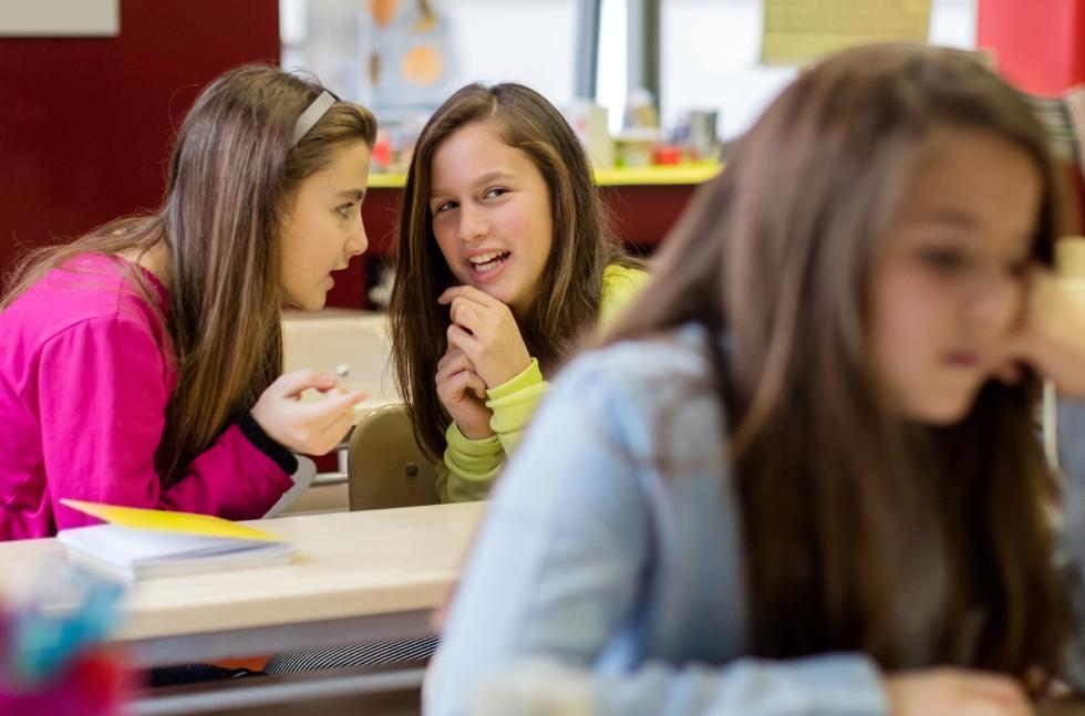 umgang-schwierige-schueler-maedchen-laestern-im-unterricht Zwei Mädchen lästern während des Unterrichts über ein anderes Mädchen