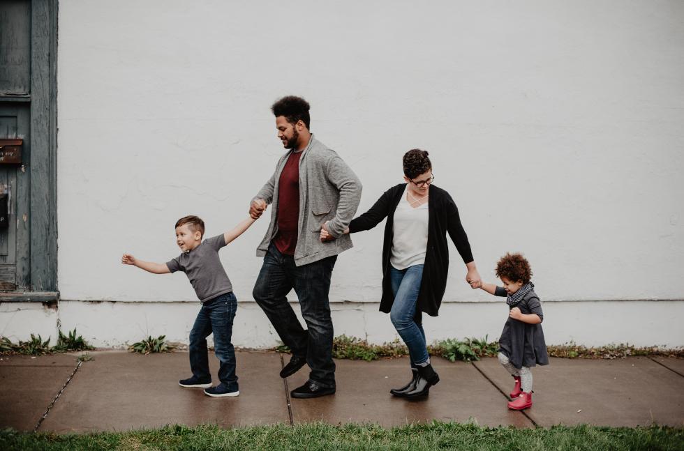 Familienberater-Familie-mit-zwei-kindern-gehen-im-Fruehlingsregen-spazieren Familien geht in Frühlingsregen spazieren, alle hörten sich an der Hand